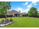 Spacious backyard with a covered patio, lush green lawn, and mature trees, ideal for outdoor activities at 416 Battlefield Creek Dr, Marietta, GA 30064