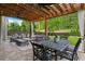 Comfortable covered patio offering a cozy seating area, dining table, and a serene view of the manicured backyard at 416 Battlefield Creek Dr, Marietta, GA 30064