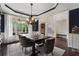 Formal dining room with dark wood floors, a stylish chandelier, and views of the landscaped yard at 416 Battlefield Creek Dr, Marietta, GA 30064