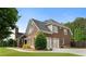 Side view of brick home with well-manicured lawn, two-car garage and mature trees at 416 Battlefield Creek Dr, Marietta, GA 30064