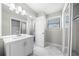 A well-lit bathroom featuring a modern vanity, a large mirror, and a glass door shower at 4347 Pleasant Ridge Rd, Decatur, GA 30034