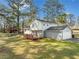 The back exterior of a beautiful home featuring a wooden deck, brick foundation, attached garage and white siding at 4347 Pleasant Ridge Rd, Decatur, GA 30034