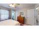 This bedroom features a window, bathroom access and a chest of drawers at 679 Suwanee Ct, Lawrenceville, GA 30043