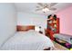 Bedroom includes ceiling fan, wooden desk, and a pink accent wall at 679 Suwanee Ct, Lawrenceville, GA 30043