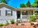 Close-up of the home's entrance with a covered porch, black door, and decorative details at 679 Suwanee Ct, Lawrenceville, GA 30043
