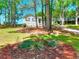 Charming home with lush green lawn, mature trees, and neatly landscaped flower beds at 679 Suwanee Ct, Lawrenceville, GA 30043