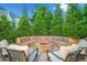 Stone fire pit and seating area in the backyard, surrounded by lush green trees and landscaping at 903 Shaftoe Nw St, Kennesaw, GA 30152