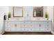 Bathroom boasts double sinks with white cabinets, marble countertop and framed mirrors at 903 Shaftoe Nw St, Kennesaw, GA 30152