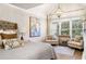 Bright bedroom features a bed, chairs, large windows, and vaulted ceiling with a modern light fixture at 903 Shaftoe Nw St, Kennesaw, GA 30152