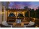 Inviting deck with pergola, string lights, fire pit, and comfortable seating at dusk offers a relaxing outdoor space at 903 Shaftoe Nw St, Kennesaw, GA 30152