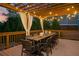 A spacious wood deck featuring a long wooden table with seating for ten, illuminated by romantic string lights at 903 Shaftoe Nw St, Kennesaw, GA 30152