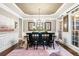 Refined dining room boasts natural light, custom wall paneling, and a statement chandelier, enhancing its elegance at 903 Shaftoe Nw St, Kennesaw, GA 30152