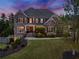 Elegant brick home illuminated at twilight, showcasing its inviting facade and manicured landscape at 903 Shaftoe Nw St, Kennesaw, GA 30152