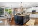 Open-concept kitchen and breakfast area with a large island, modern lighting, and hardwood floors, perfect for entertaining at 903 Shaftoe Nw St, Kennesaw, GA 30152
