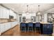 Open kitchen features white cabinets, large island with seating, granite counters and modern appliances at 903 Shaftoe Nw St, Kennesaw, GA 30152