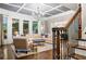 Sophisticated living room features a coffered ceiling, large windows, and a comfortable seating arrangement for relaxation at 903 Shaftoe Nw St, Kennesaw, GA 30152