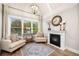 Living room includes a fireplace, chairs, decor, a large window, and a modern light fixture at 903 Shaftoe Nw St, Kennesaw, GA 30152