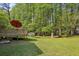 Backyard with a lush green lawn, shade trees, and a deck with a brown umbrella at 1649 Clairmont Ne Way, Brookhaven, GA 30329