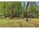 Spacious backyard with mature trees, a fire pit, and Adirondack chairs for outdoor relaxation at 1649 Clairmont Ne Way, Brookhaven, GA 30329