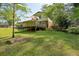 Backyard view of a house with a deck and fenced yard, surrounded by lush trees and greenery at 1649 Clairmont Ne Way, Brookhaven, GA 30329