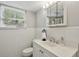 Bathroom with white tile walls, vanity with marble countertop, mirror, toilet, and window at 1649 Clairmont Ne Way, Brookhaven, GA 30329