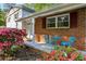 Inviting front porch with brick accents, colorful flowers, and outdoor seating for relaxation at 1649 Clairmont Ne Way, Brookhaven, GA 30329