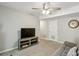 Cozy living room with neutral tones, ceiling fan, TV and cabinet, couch, clock and white door at 1649 Clairmont Ne Way, Brookhaven, GA 30329