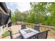 Outdoor deck featuring a dining table, chairs, and a view of the lush backyard and surrounding trees at 2619 Kellogg Creek Rd, Acworth, GA 30102