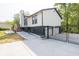 Side exterior with stone foundation, gray gravel, and gated driveway at 2619 Kellogg Creek Rd, Acworth, GA 30102