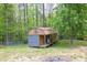 Large shed on the property with a metal roof provides extra storage or workshop space surrounded by a wooded, private setting at 2619 Kellogg Creek Rd, Acworth, GA 30102