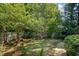 Serene backyard retreat featuring a well-maintained lawn, mature trees, and a cozy bench at 2990 Byrons Green Ct, Marietta, GA 30062