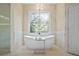 Bright bathroom featuring a freestanding tub below a decorative window and a glass enclosed shower at 2990 Byrons Green Ct, Marietta, GA 30062
