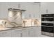Modern white kitchen with stainless steel appliances and stylish backsplash at 2990 Byrons Green Ct, Marietta, GA 30062