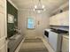 Bright laundry room with decorative rug, shelving, and side door access at 2990 Byrons Green Ct, Marietta, GA 30062