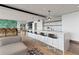 Modern kitchen features a long breakfast bar with stylish pendant lighting and light wood floors at 943 Peachtree Ne St # 2002, Atlanta, GA 30309
