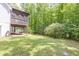 View of a lush backyard with a screened porch elevated with wooded backdrop at 2009 Shipwreck Ct, Buford, GA 30518