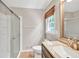 Bathroom featuring a shower with glass doors, a window with a bamboo shade, and dark wood cabinets at 2009 Shipwreck Ct, Buford, GA 30518