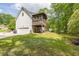 Side view of home with a two-car garage and elevated screened-in back porch at 2009 Shipwreck Ct, Buford, GA 30518