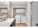 A well-lit laundry room with white cabinets, side-by-side washer and dryer, and light colored walls at 2009 Shipwreck Ct, Buford, GA 30518