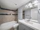 Clean bathroom featuring a tub with shower, gray vanity and unique tile design at 2102 Palmyra Se Dr, Marietta, GA 30067