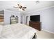 Spacious bedroom features neutral colors, ceiling fan, shelving unit, television and walk-in bathroom at 2102 Palmyra Se Dr, Marietta, GA 30067
