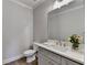 Elegant half bathroom featuring a gray vanity, a rectangular mirror, and neutral paint color at 6065 Cushing Cir, Norcross, GA 30071