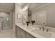Luxurious bathroom with double sink vanity, marble countertops, tiled floors, and a glass-enclosed shower at 6065 Cushing Cir, Norcross, GA 30071