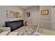 Bright bedroom featuring a crib, soft rug, chair and ottoman, and a blue painted dresser at 6065 Cushing Cir, Norcross, GA 30071