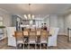 Dining room showcases a stylish chandelier, hardwood flooring, and views into the modern kitchen at 6065 Cushing Cir, Norcross, GA 30071
