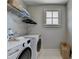 Well-organized laundry room featuring a modern washer and dryer, wire shelving and a window for natural light at 6065 Cushing Cir, Norcross, GA 30071