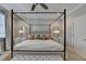 Main bedroom featuring a four-poster bed, neutral walls, ceiling fan, a bench, and natural light from windows at 6065 Cushing Cir, Norcross, GA 30071