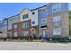A row of stylish townhouses shows unique brick and siding exteriors with colorful front doors and tidy landscaping at 6065 Cushing Cir, Norcross, GA 30071