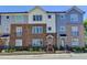 A row of stylish townhouses shows unique brick and siding exteriors with colorful front doors and tidy landscaping at 6065 Cushing Cir, Norcross, GA 30071