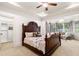 Primary bedroom suite featuring a sitting area with a chandelier, windows, and a large bed at 841 Camden Park Ne Ct, Atlanta, GA 30342